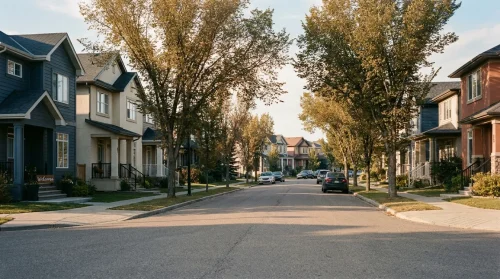 A quiet, tree-lined residential street in an Edmonton neighborhood with a welcoming sign on a house, conveying a sense of new beginnings.