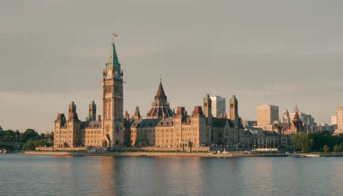 Cinematic view of the Canadian Parliament building in Ottawa at golden hour, reflected in the Ottawa River.