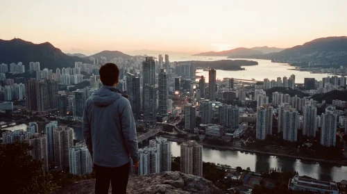Anonymous person looking out over a Canadian city at dawn, symbolizing aspiration for a new life without a job offer.